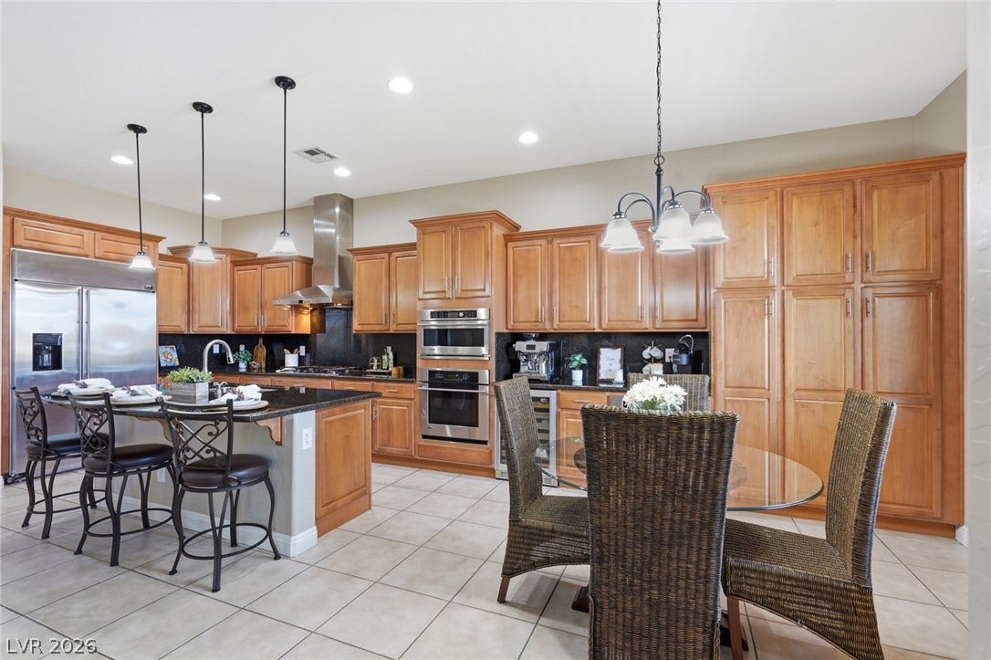 2397 Luberon Drive, Henderson, NV 89044 A chef's dream kitchen, offering abundant wood cabinetry and professional-grade stainless steel appliances for culinary excellence.