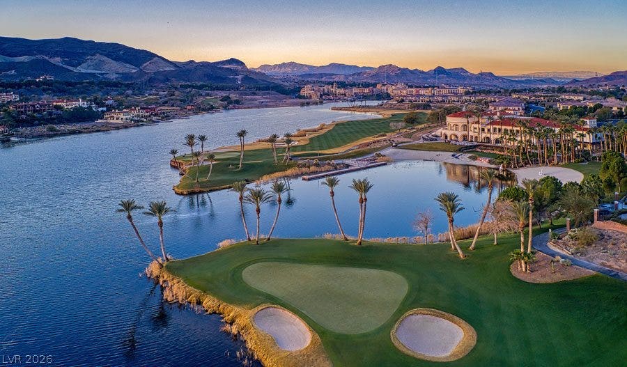 6 VIA VASARI, #102, Henderson, NV 89011 A golf course alongside a sparkling lake, framed by distant mountains.
