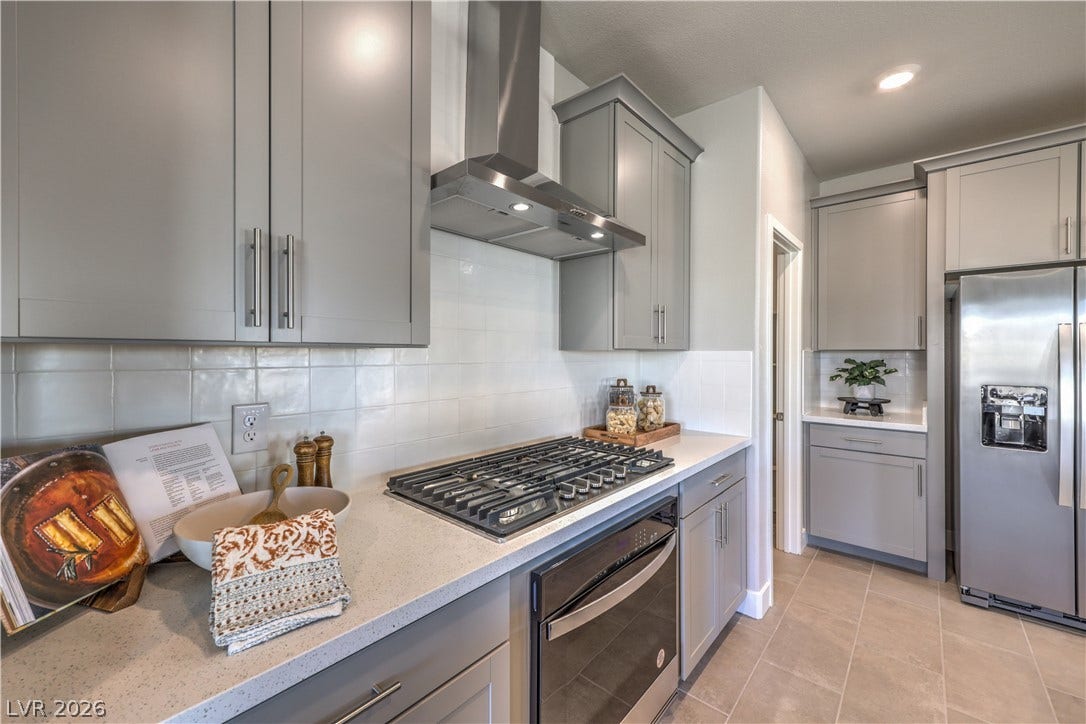 Modern kitchen with sleek gray cabinetry and robust stainless steel appliances for culinary excellence.