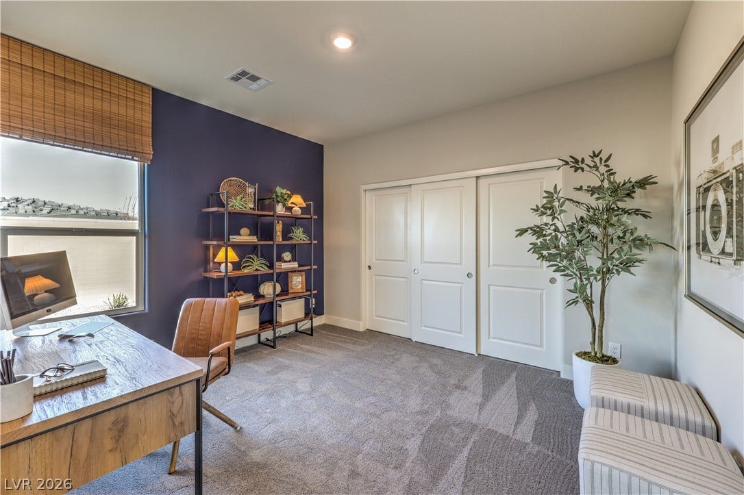 A well-appointed office space boasts ample storage with built-in features and plush carpeting.