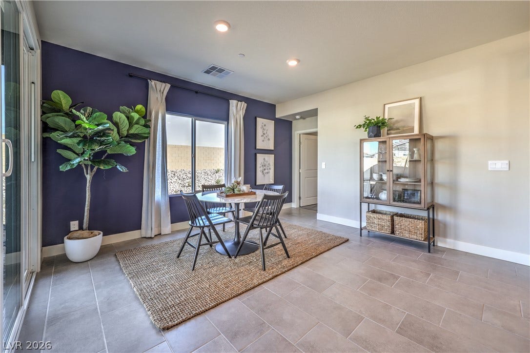 Recessed lighting illuminates this versatile dining space with modern tile flooring.