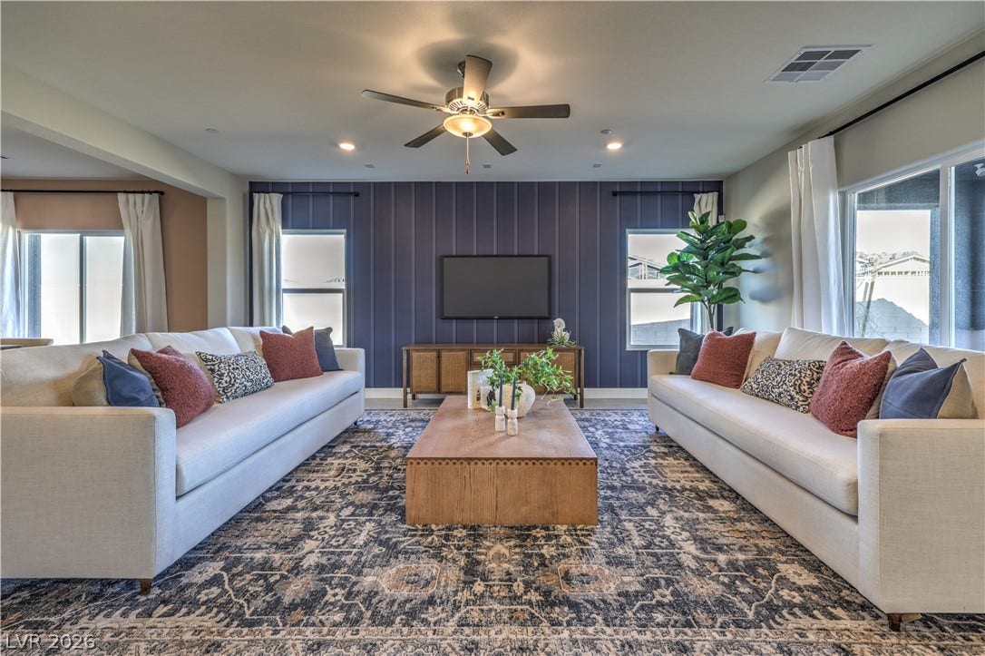 A spacious living area with recessed lighting and a ceiling fan, offering a comfortable and inviting atmosphere.