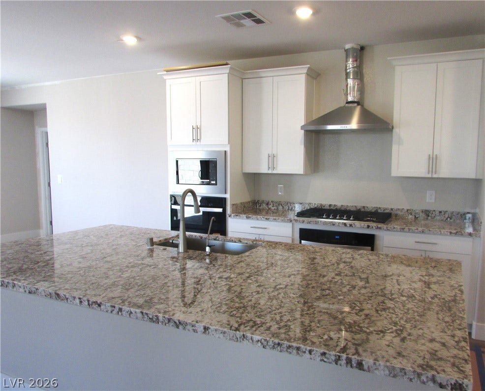 Polished granite countertops anchor this kitchen designed with a generous central island. Photo is of actual home.