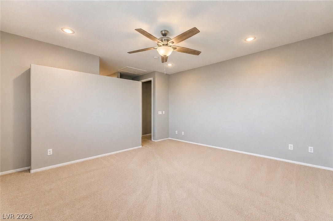 2439 Kaymin Ridge Road, Henderson, NV 89052 A well-lit bedroom features plush carpeting and a convenient ceiling fan.