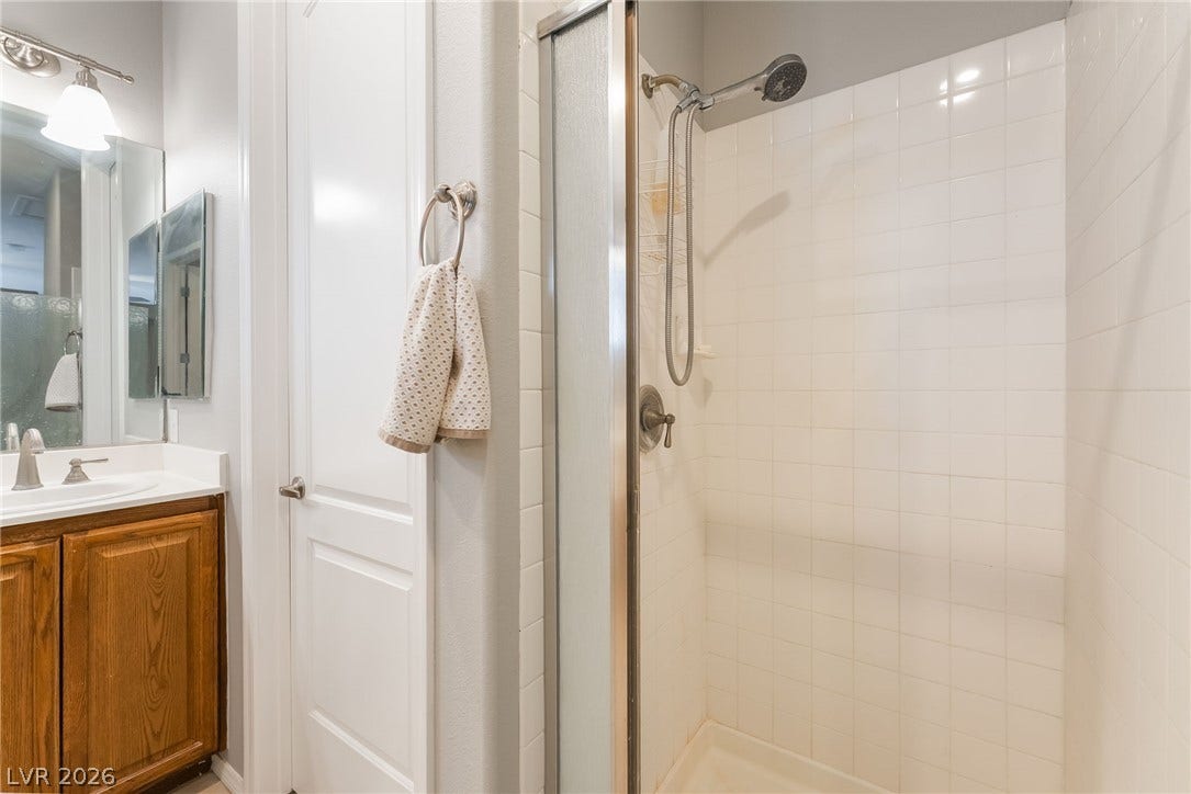 2439 Kaymin Ridge Road, Henderson, NV 89052 A well-appointed bathroom offers a practical vanity and a glass-enclosed shower.