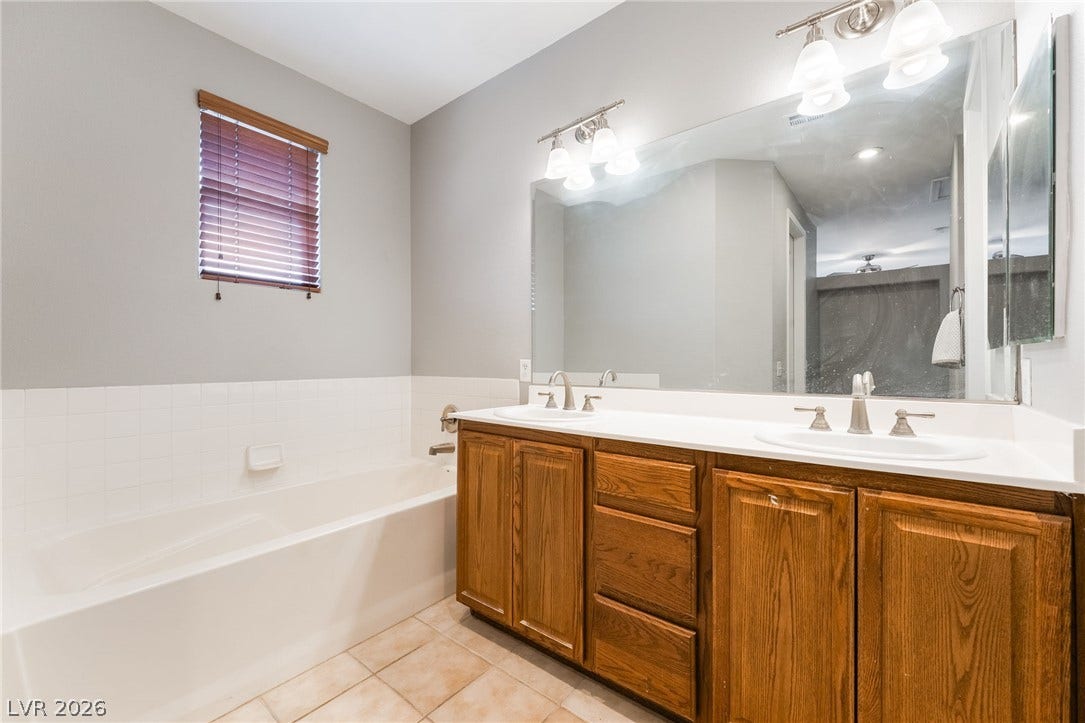 2439 Kaymin Ridge Road, Henderson, NV 89052 Double vanity and a deep soaking tub create a comfortable, functional bathroom retreat.