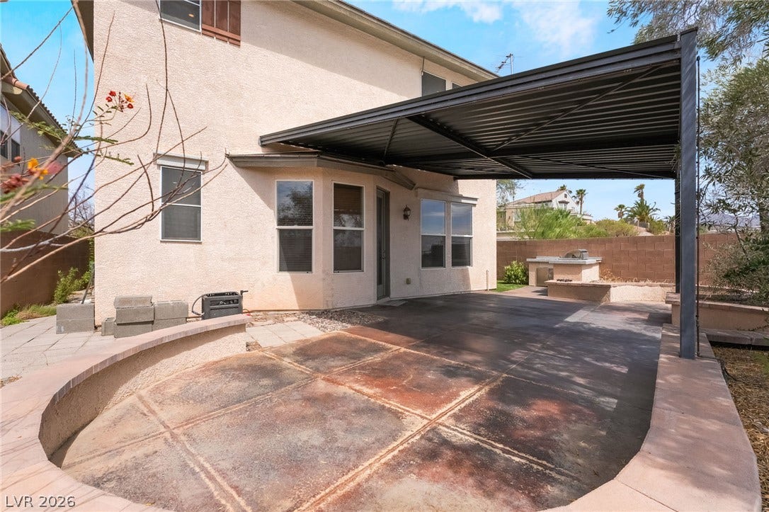 2439 Kaymin Ridge Road, Henderson, NV 89052 An inviting covered patio provides a perfect outdoor living space, featuring an integrated barbecue for al fresco dining.