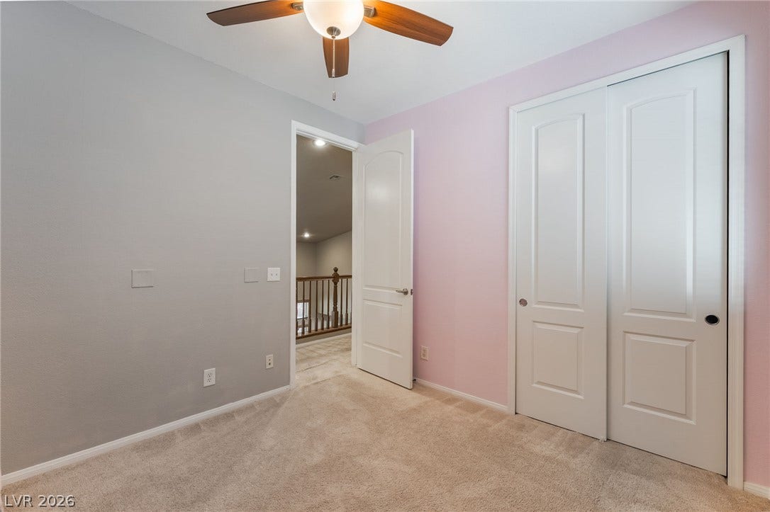 2439 Kaymin Ridge Road, Henderson, NV 89052 A well-lit bedroom with soft carpet, complete with a functional ceiling fan for optimal comfort.
