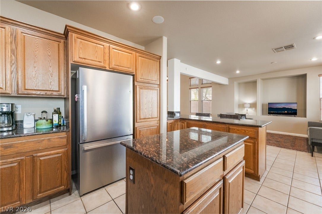 2439 Kaymin Ridge Road, Henderson, NV 89052 An inviting kitchen with rich wood cabinetry and ample counter space, perfect for culinary adventures.