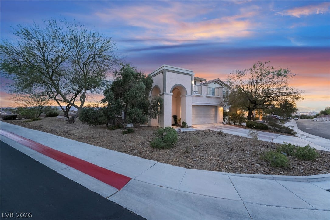 2439 Kaymin Ridge Road, Henderson, NV 89052 Arched entryways and stucco facade enhance this modern desert residence under a captivating sky.