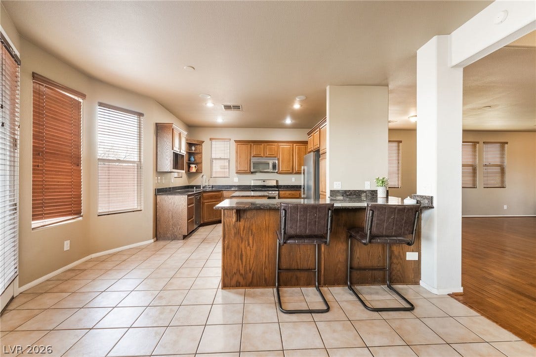 2439 Kaymin Ridge Road, Henderson, NV 89052 A well-appointed kitchen features a practical breakfast bar and ample counter space for culinary endeavors.