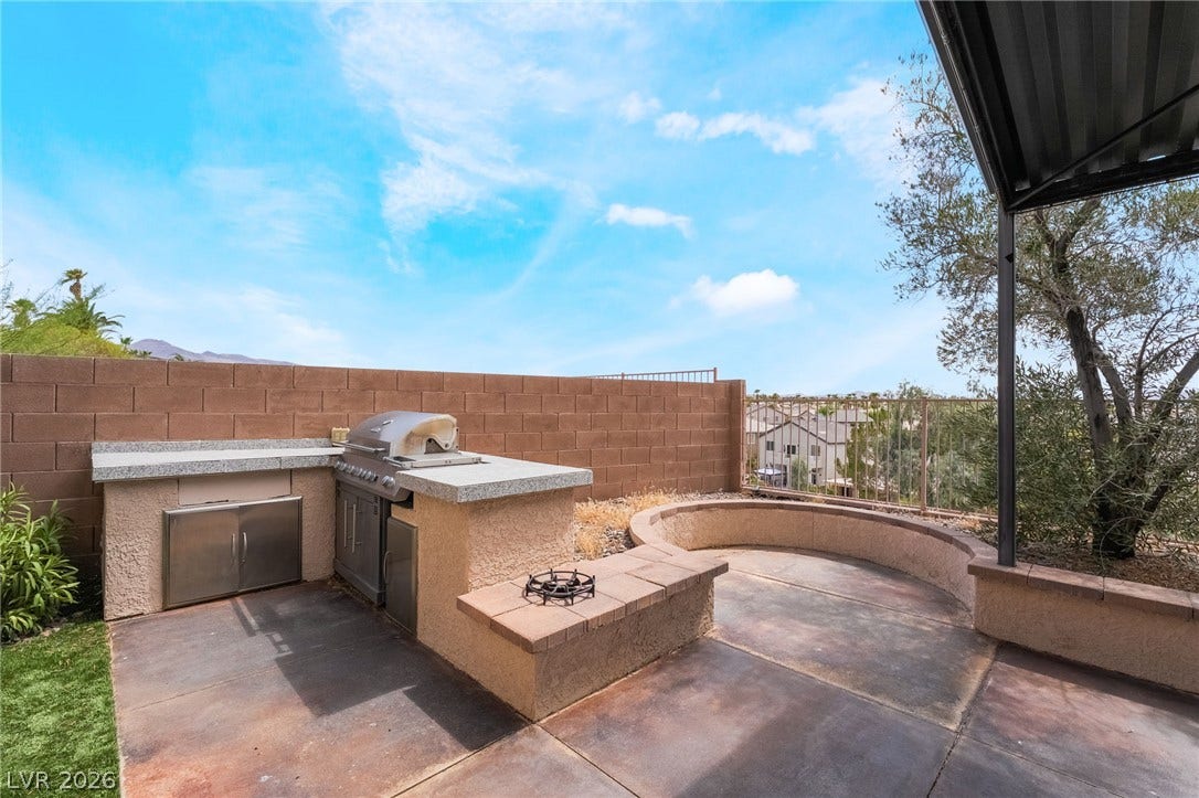 2439 Kaymin Ridge Road, Henderson, NV 89052 An inviting outdoor kitchen and seating area offer al fresco dining and relaxation.