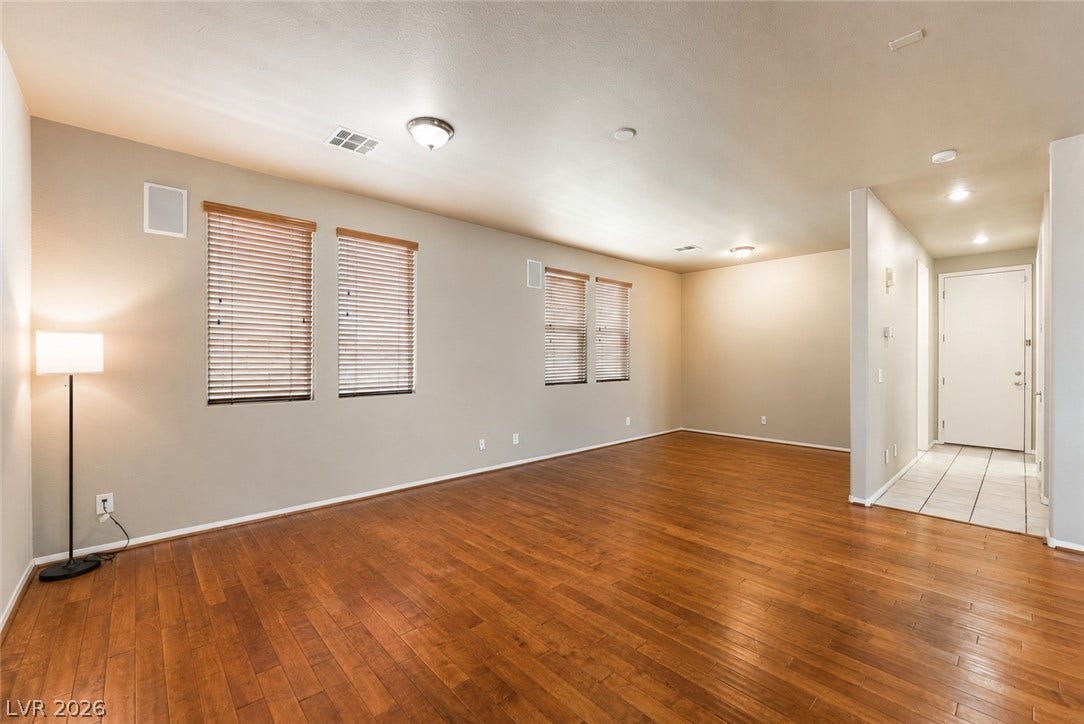 2439 Kaymin Ridge Road, Henderson, NV 89052 Natural light filters through the blinds, illuminating the rich wood flooring throughout this adaptable interior space.