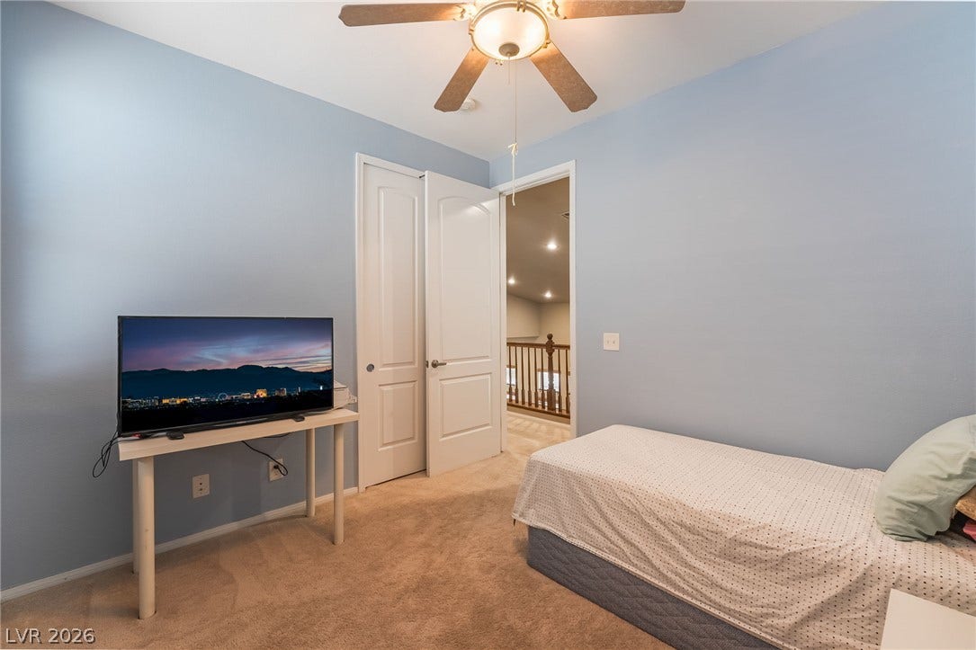 2439 Kaymin Ridge Road, Henderson, NV 89052 A comfortable bedroom with soft carpeting and a ceiling fan, offering a cozy retreat.