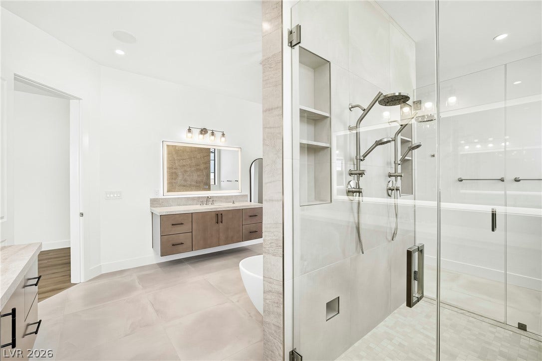 4360 Conough Lane, Las Vegas, NV 89129 Modern primary bathroom featuring dual shower heads and a sleek floating vanity with generous storage.