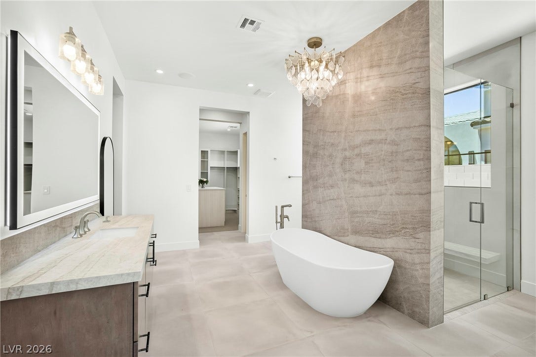 4360 Conough Lane, Las Vegas, NV 89129 Luxurious bathroom with a freestanding tub, expansive vanity, and elegant glass-enclosed shower.