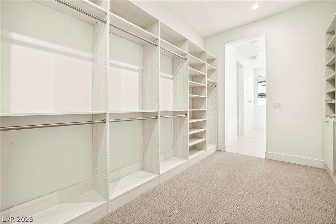 4360 Conough Lane, Las Vegas, NV 89129 Custom-designed closet shelving and hanging rods offer ample storage space, leading to a well-lit corridor.