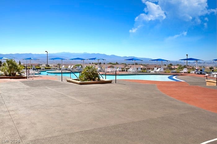 2141 Colvin Run Drive, Henderson, NV 89052 A refreshing community pool area with shade umbrellas, surrounded by desert landscaping and distant mountains.