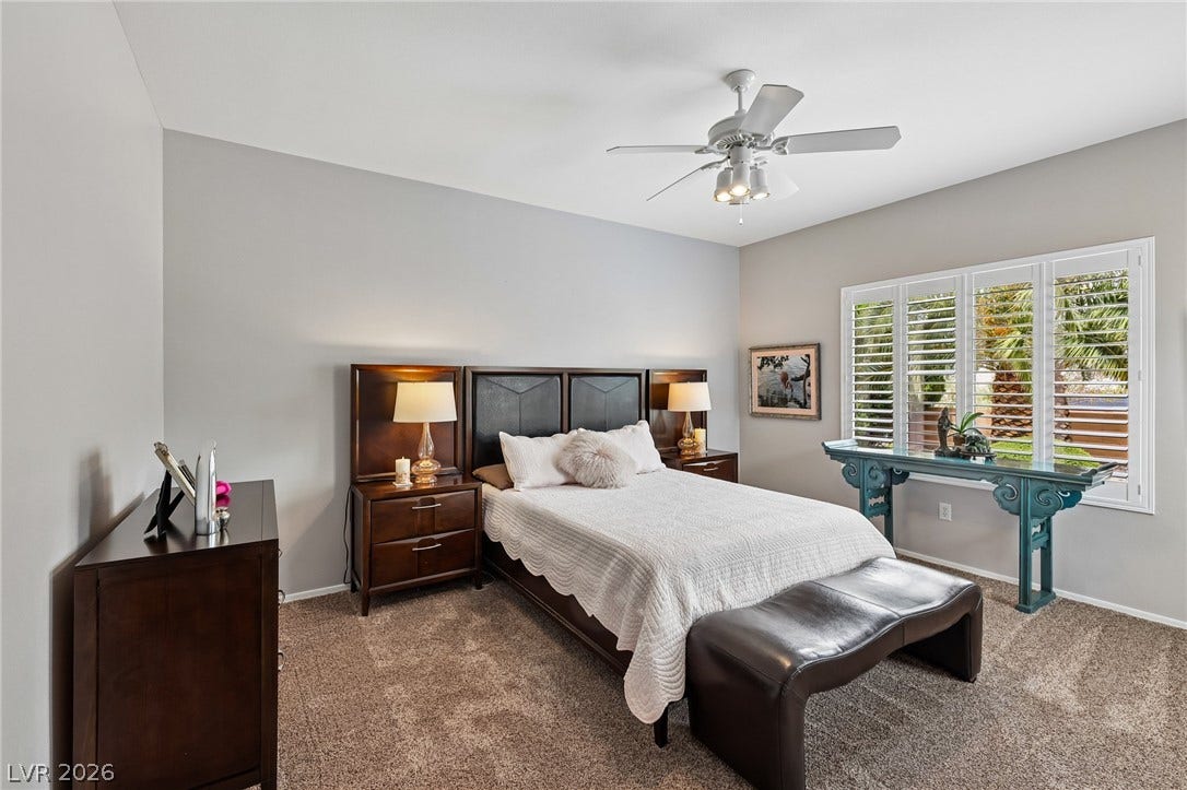2141 Colvin Run Drive, Henderson, NV 89052 The primary bedroom features a textured carpet and a window with plantation shutters.