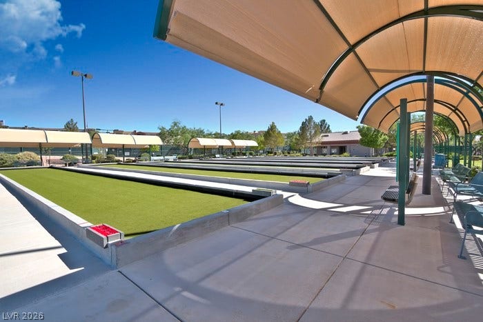 2141 Colvin Run Drive, Henderson, NV 89052 A vibrant community outdoor space featuring multiple manicured bocce ball courts under a brilliant blue sky, complete with shaded seating areas.