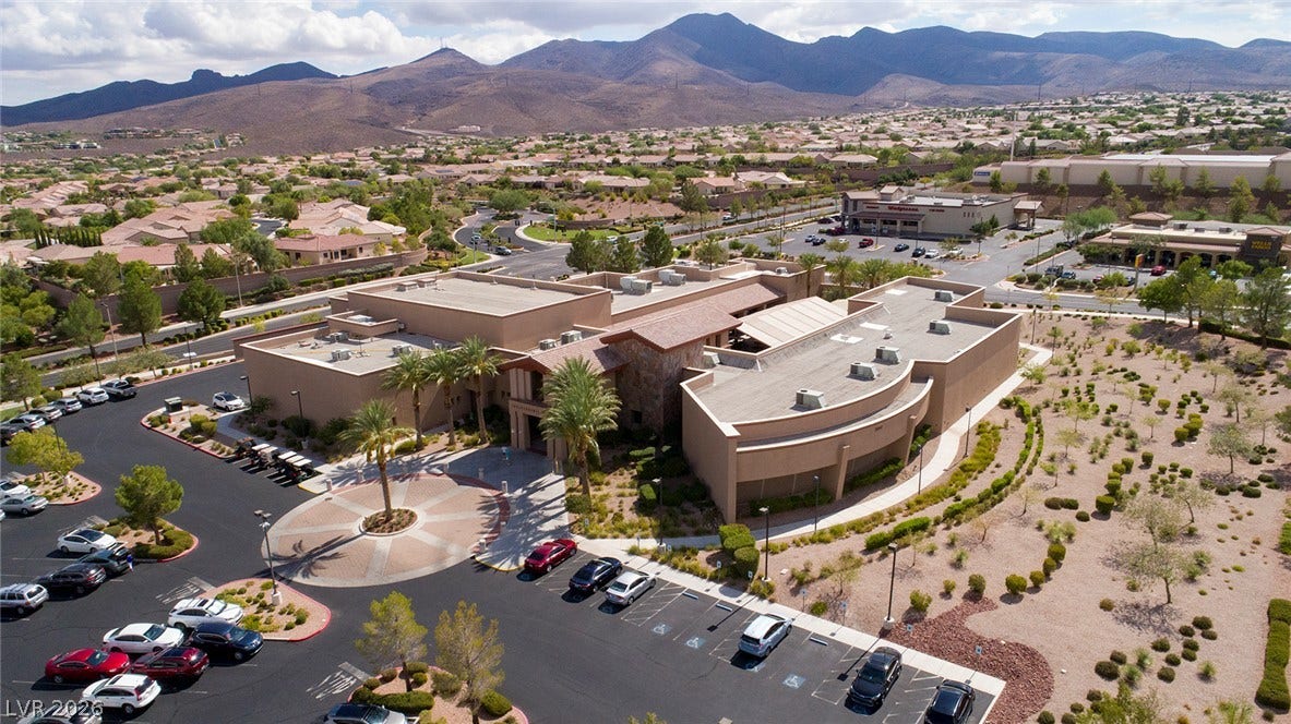 2141 Colvin Run Drive, Henderson, NV 89052 An aerial perspective reveals Sun City Anthem's "Independence Center" nestled among a vast residential community, framed by rugged mountains.