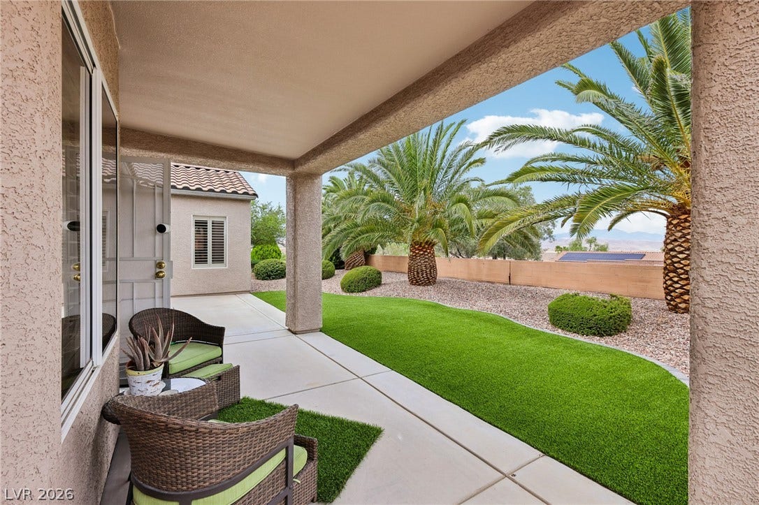 2141 Colvin Run Drive, Henderson, NV 89052 An inviting covered patio opens to a vibrant artificial lawn and desert-inspired landscaping.