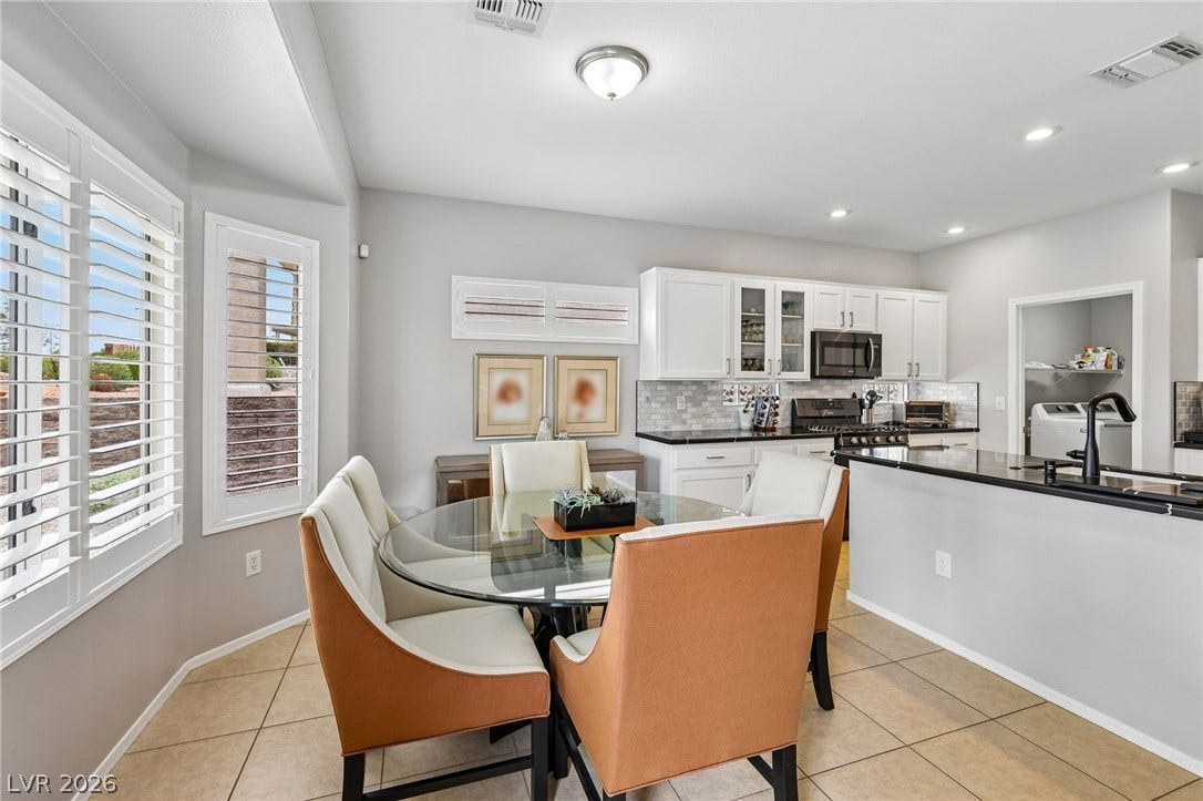 2141 Colvin Run Drive, Henderson, NV 89052 A well-lit dining area featuring a modern glass-top table, stylish chairs, and practical tile flooring.