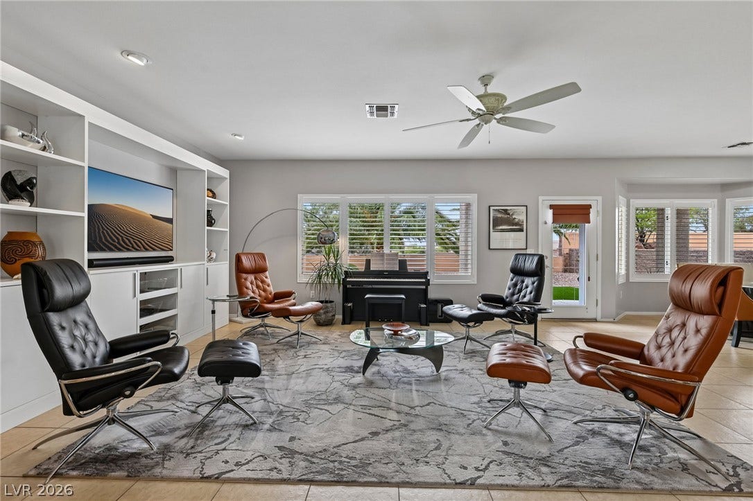 2141 Colvin Run Drive, Henderson, NV 89052 A relaxed living area presents built-in shelving, tile flooring, and ample natural light from multiple windows.