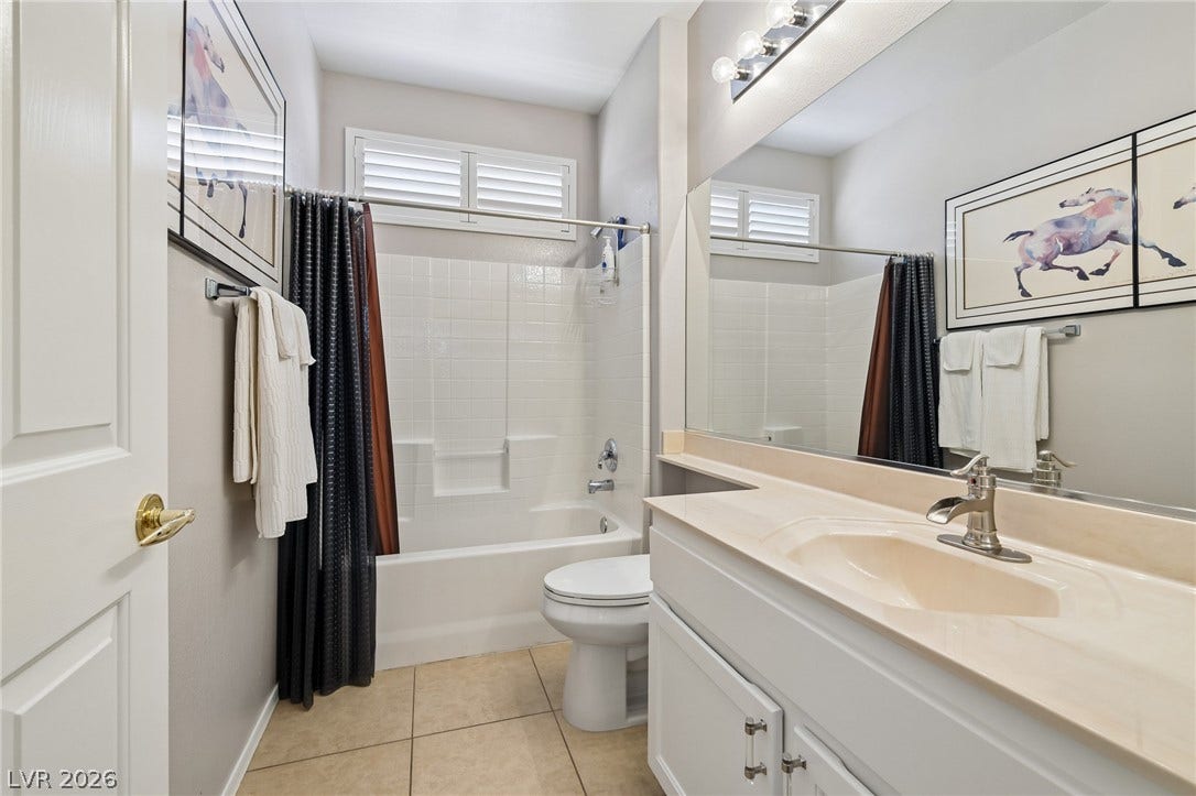 2141 Colvin Run Drive, Henderson, NV 89052 A well-lit bathroom features a vanity with a large mirror, a shower-tub combination, and tiled flooring.