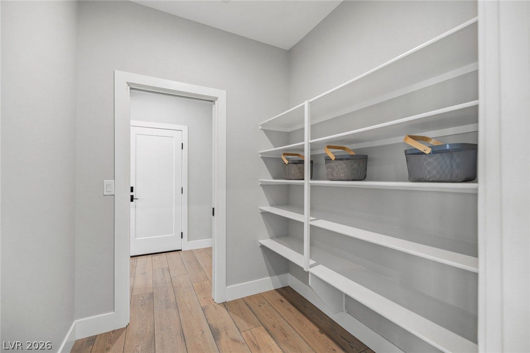 3194 Poplar Crest Court, Henderson, NV 89044 A well-organized pantry features abundant shelving for optimal storage, complementing the rich wood flooring.