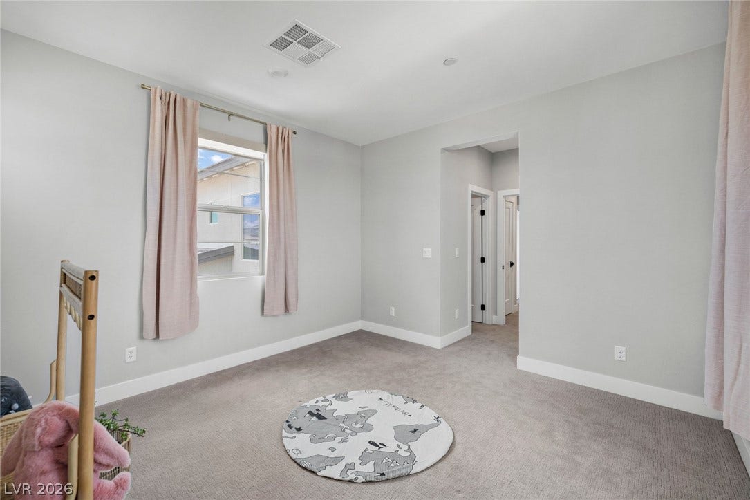 3194 Poplar Crest Court, Henderson, NV 89044 A well-lit bedroom awaits personalization, offering a tranquil space with soft carpeting and natural illumination.