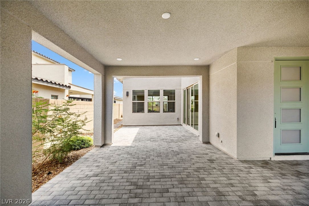 3194 Poplar Crest Court, Henderson, NV 89044 A sheltered outdoor area with paver flooring offers a seamless transition to the interior through a sliding glass door.