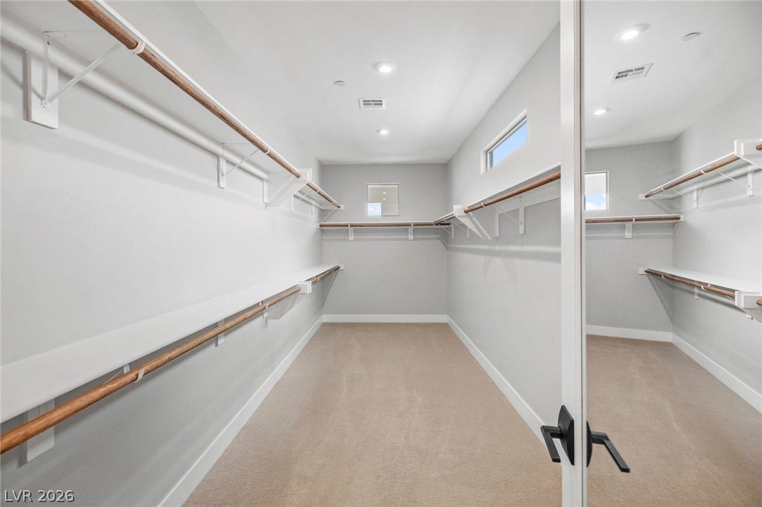 3194 Poplar Crest Court, Henderson, NV 89044 Ample storage solutions await in this naturally illuminated walk-in closet with carpeted flooring.