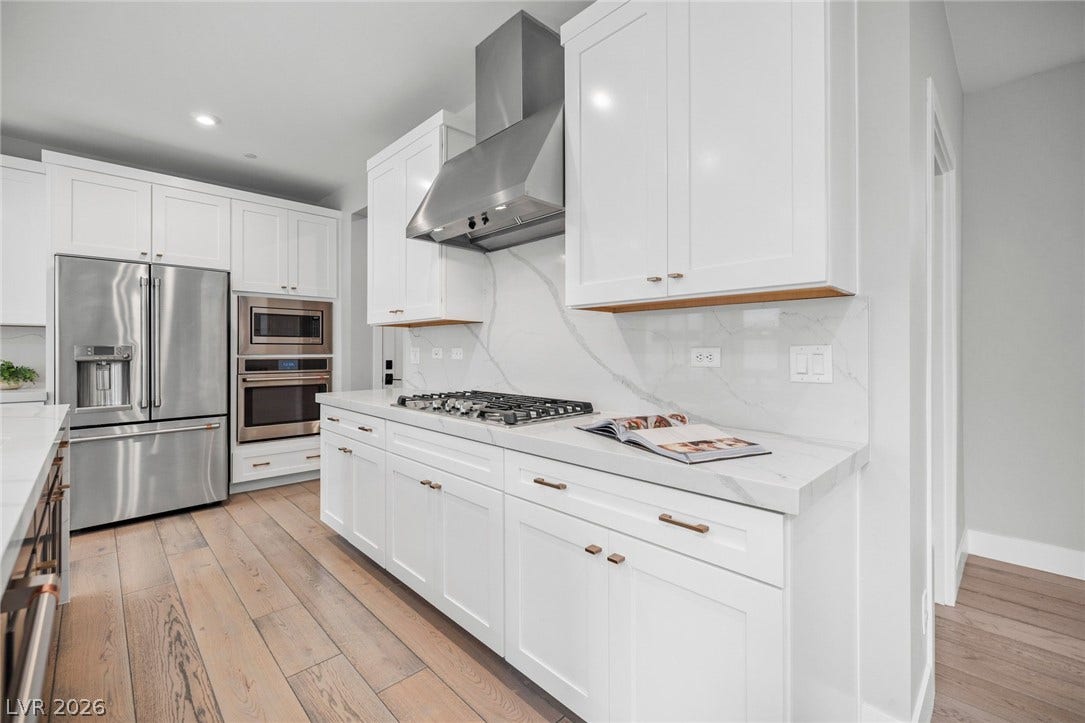 3194 Poplar Crest Court, Henderson, NV 89044 Culinary dreams come alive in this well-appointed kitchen featuring a gas range and gleaming stainless steel appliances.