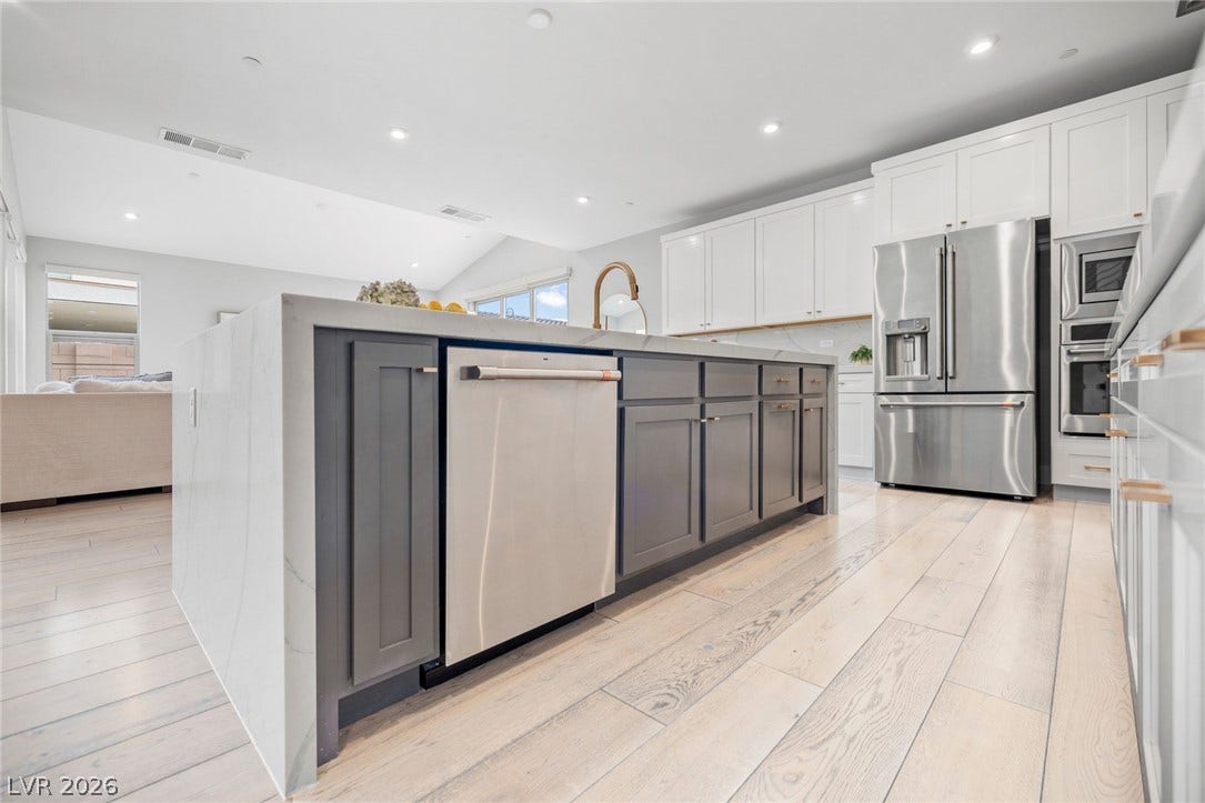 3194 Poplar Crest Court, Henderson, NV 89044 A well-lit kitchen featuring a spacious island, contemporary cabinetry, and lustrous stainless steel appliances.