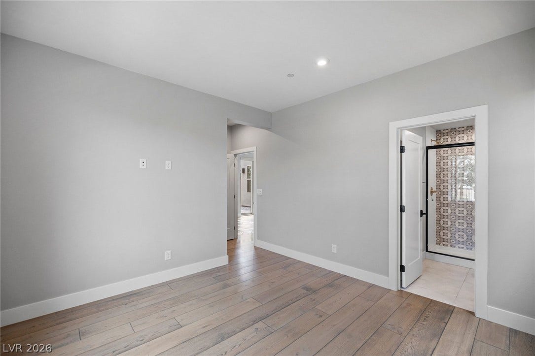 3194 Poplar Crest Court, Henderson, NV 89044 Natural wood flooring complements clean walls, leading to a stylish en-suite bathroom.