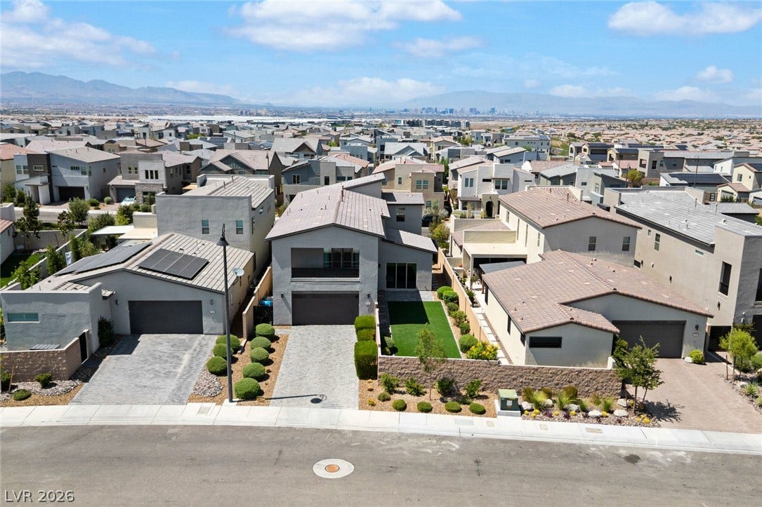 3194 Poplar Crest Court, Henderson, NV 89044 An aerial perspective reveals a modern neighborhood of homes, each with a neatly landscaped front yard and a view of the distant cityscape.
