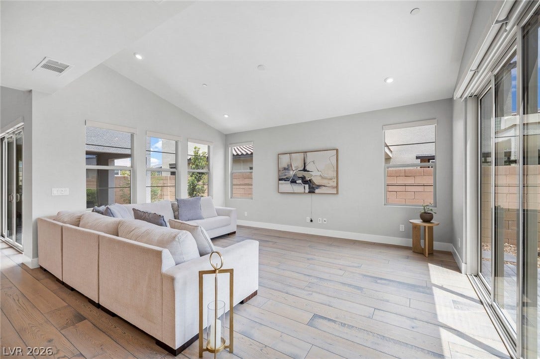3194 Poplar Crest Court, Henderson, NV 89044 Natural light streams into this generously sized living room, showcasing beautiful hardwood flooring and high ceilings.