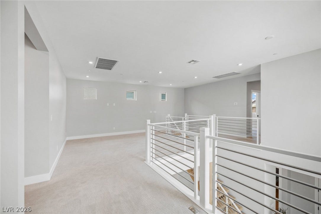 3194 Poplar Crest Court, Henderson, NV 89044 An airy loft area features sleek railing and soft carpeting, creating a versatile and inviting space.