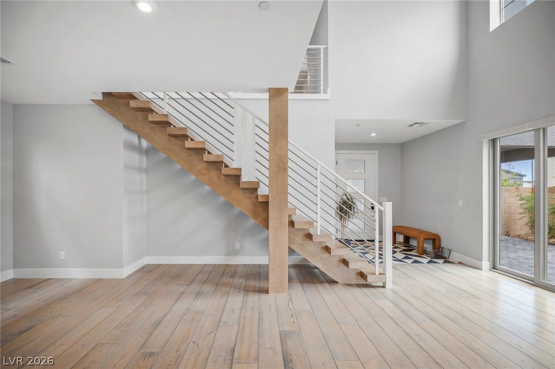 3194 Poplar Crest Court, Henderson, NV 89044 Modern wood and metal staircase anchors this bright, open-concept living space with ample natural light.