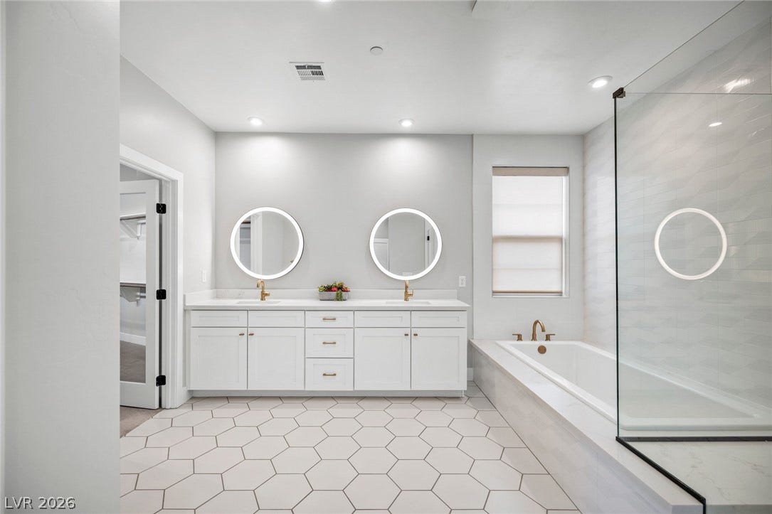 3194 Poplar Crest Court, Henderson, NV 89044 A well-appointed primary bathroom features dual vanities, hexagon tile flooring, and a spacious soaking tub.