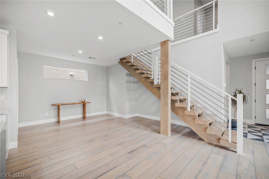 3194 Poplar Crest Court, Henderson, NV 89044 A striking modern staircase with sleek railing anchors this open-concept living space.