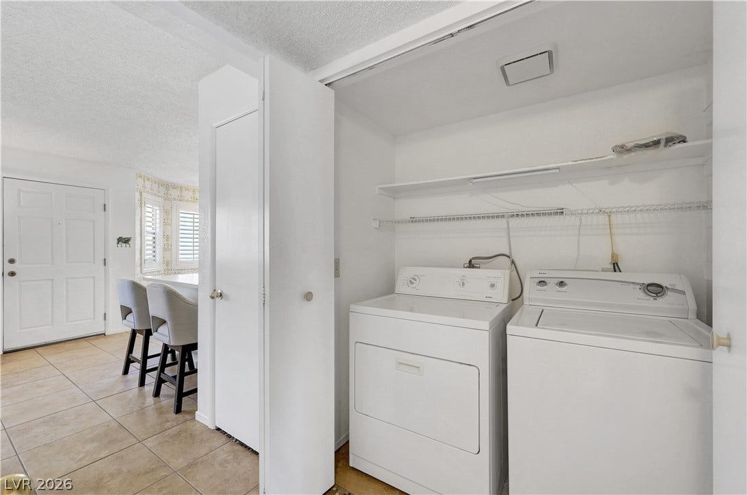 A well-appointed laundry area offers convenient in-home utility access with practical shelving.