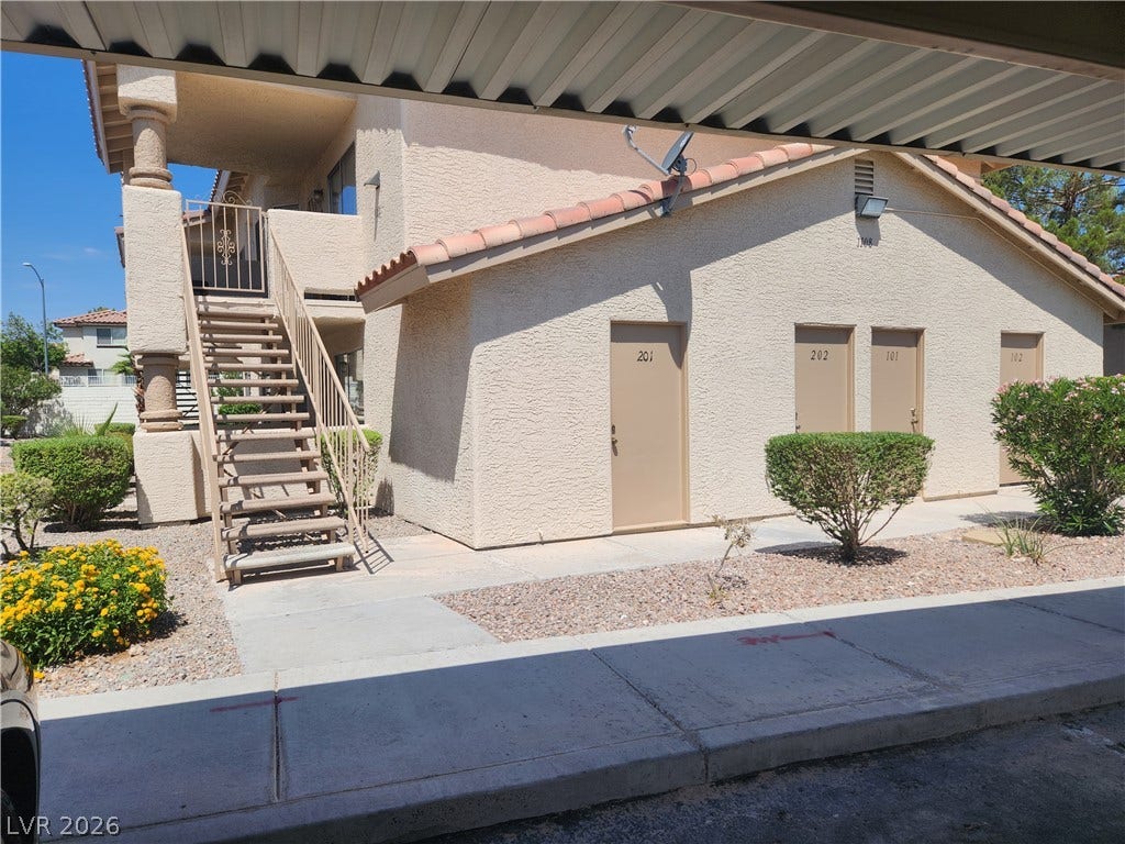 A welcoming exterior with stairs leading to upper units and individual ground-floor access points.