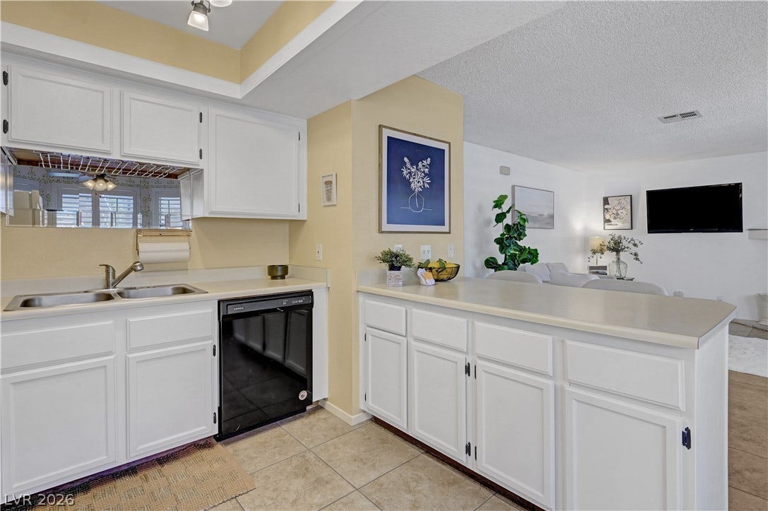 A well-appointed kitchen space boasts ample cabinetry and practical counter surfaces, seamlessly connecting to the living area.