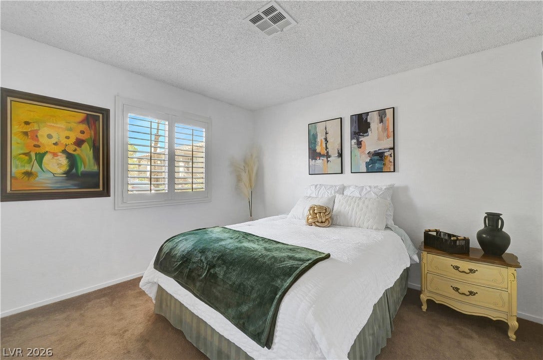 Comfortable carpeting and ample natural light define this cozy and inviting sleeping area.