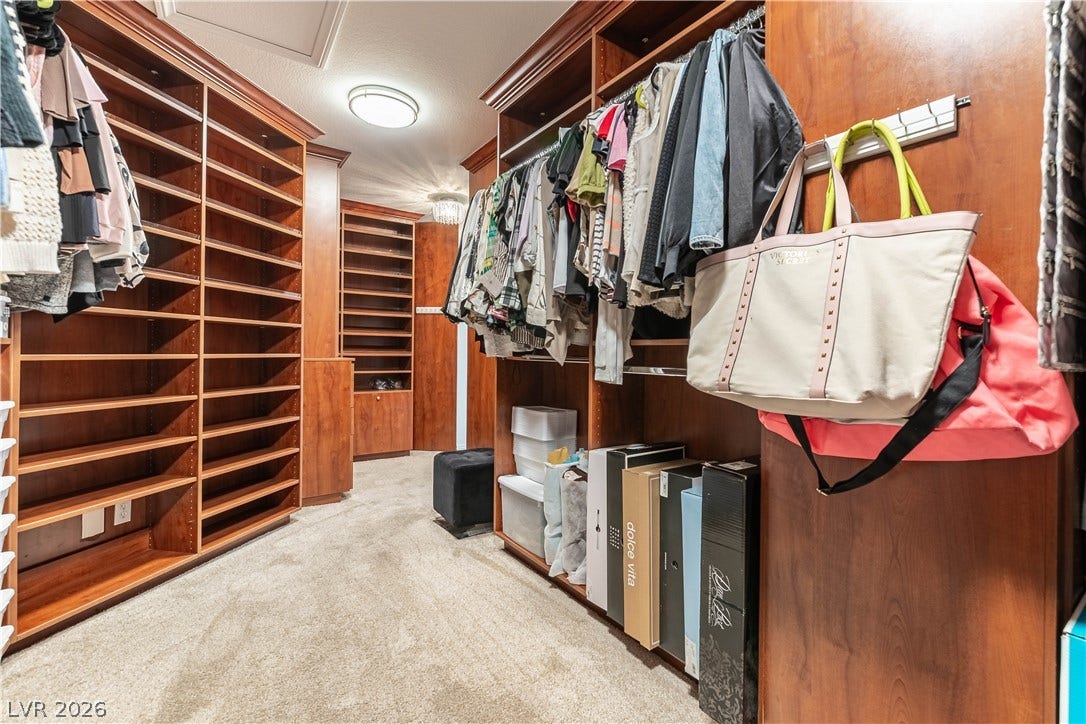 2676 Botticelli Drive, Henderson, NV 89052 Large walk-in closet with custom cabinetry with built-in shelving and hanging racks creates an organized and nice dressing space.