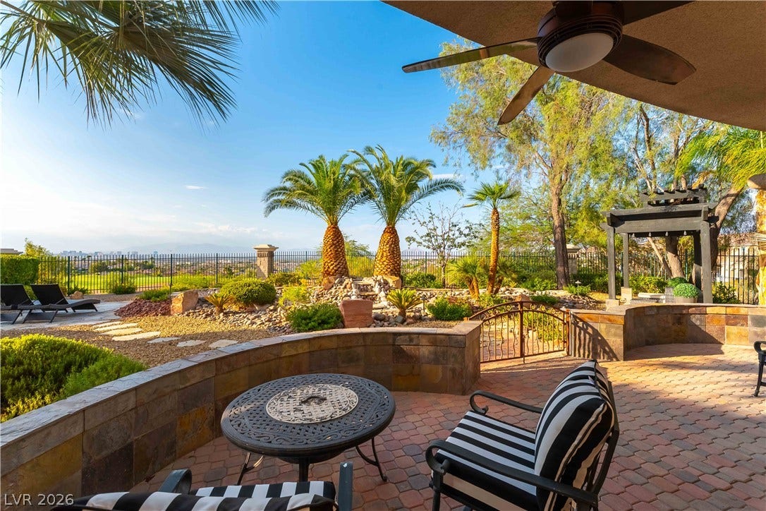 2676 Botticelli Drive, Henderson, NV 89052 Beautiful outdoor living space features a paver stone patio, detached lattice patio, water feature, lush landscaping, and panoramic city views.