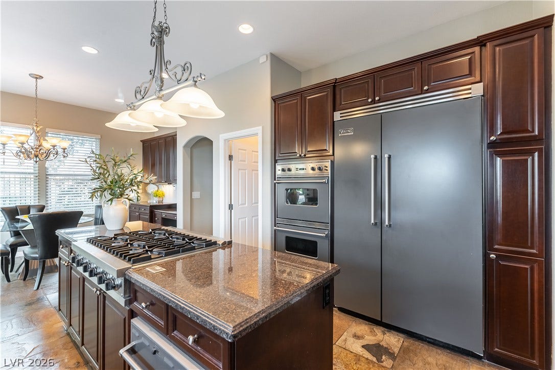 2676 Botticelli Drive, Henderson, NV 89052 Culinary delights await in this chef's kitchen featuring Viking stainless built-in refrigerator, large double ovens, stacked 2 drawer dishwasher, warming drawer and biult-in microwave oven.