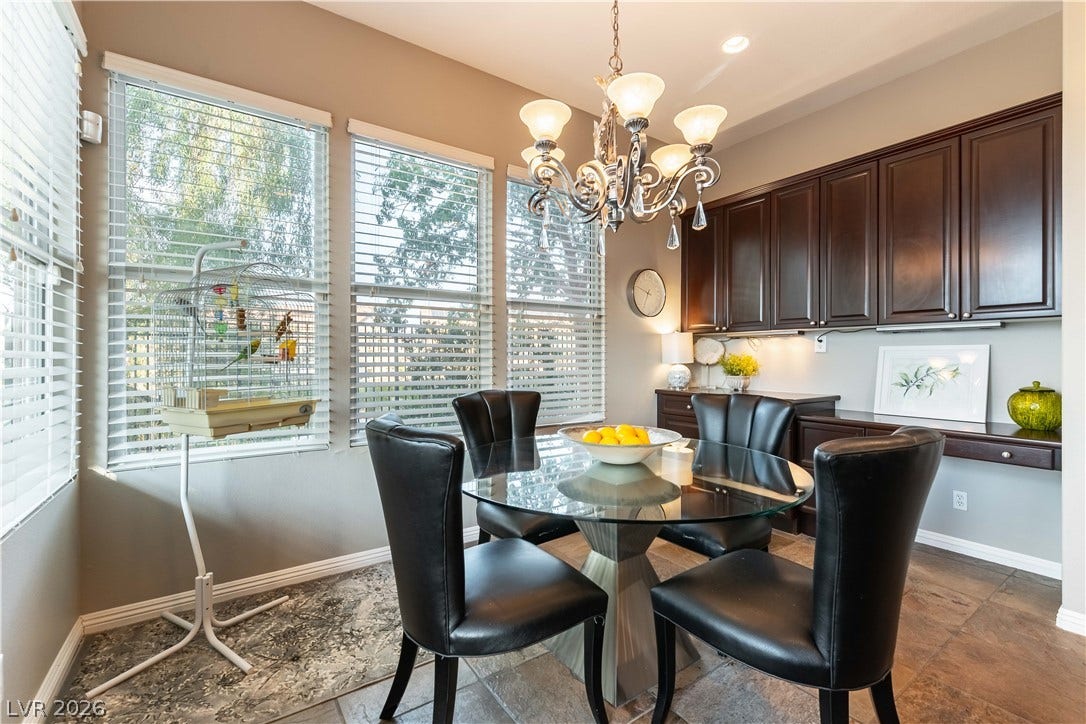 2676 Botticelli Drive, Henderson, NV 89052 This breakfast nook, with lots of natural light, features rich cabinetry, a stylish chandelier, and slate tile flooring.